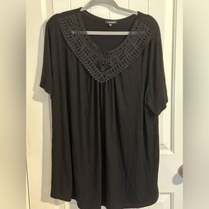 Chic Black top with embroidered detail at neckline.